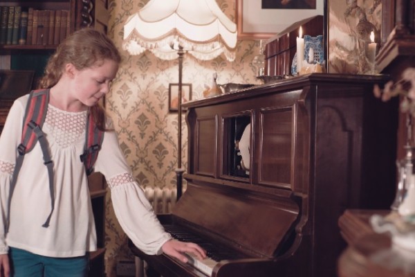 Young lady lookig at old piano on her family day out in Milton Keynes