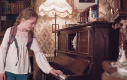 Young lady lookig at old piano on her family day out in Milton Keynes