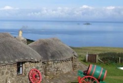 Ancient cottage with thatch roof overlooking the sea on the Isle of Skye
