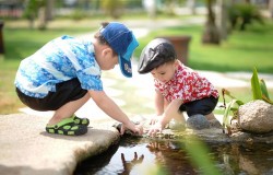 2 children playing with water on their family day out