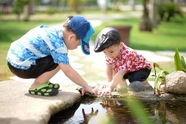 2 children playing with water on their family day out