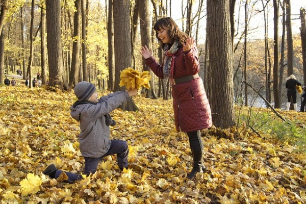 In the park with the kids playing in the Autumn leaves