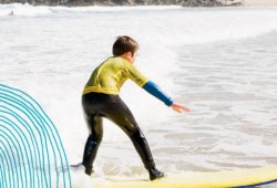 Kids Days Out in Cornwall - image of boy surfer riding the waves